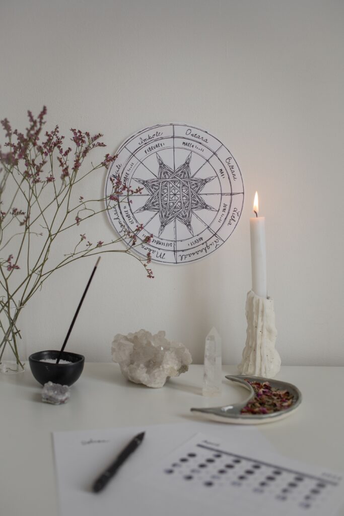 Cozy spiritual setting with candle, crystals, and astrology chart for peaceful meditation.