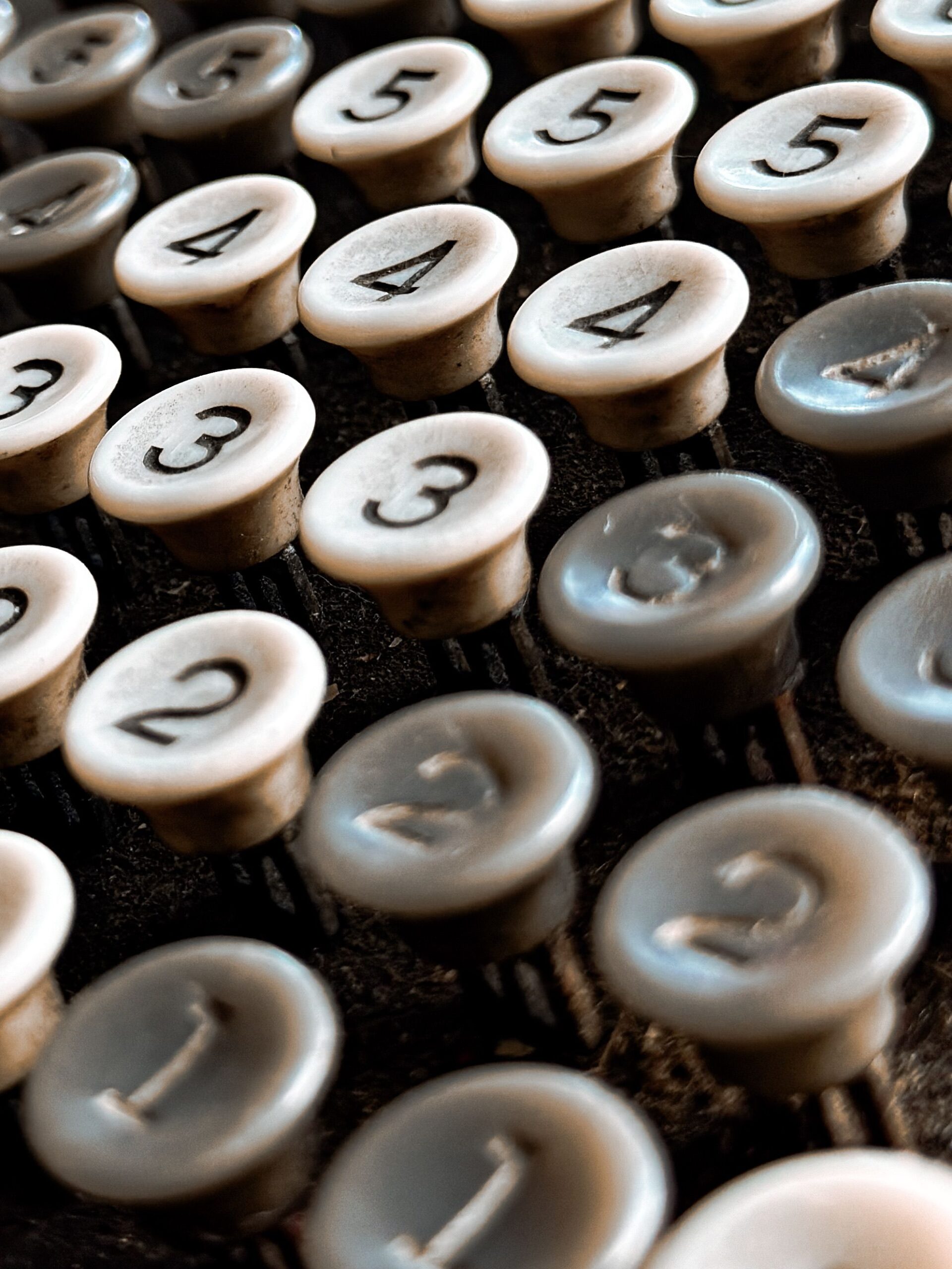 Close-up shot of vintage typewriter keys depicting numbers, showcasing old-fashioned technology.